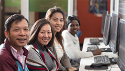 People sitting in front of computers smiling